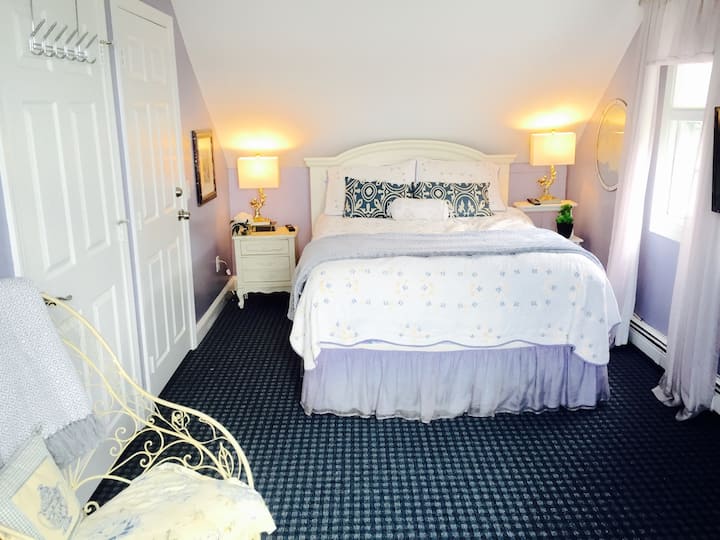 ห้องพักชั้นบนห้องที่สองพร้อมเตียงควีนไซส์และพื้นที่นั่งเล่น