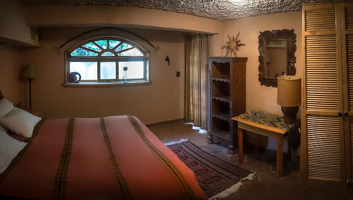 Dormitorio de jardín con cama tamaño queen y acceso privado al jardín