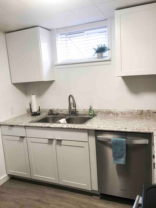 Kitchen complete with basic cooking utensils, dishwasher, stove and fridge
