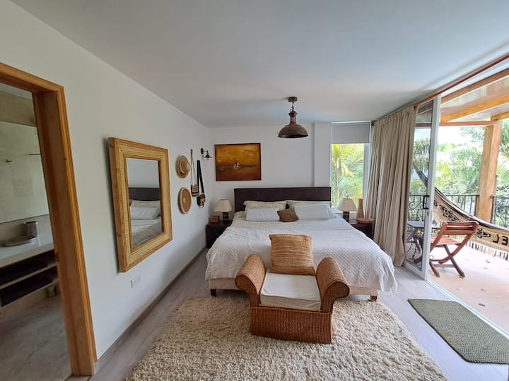 Master bedroom for two, with a king-size bed, on the second floor, closet, large balcony with a Wayuu hammock, and private bathroom with bathtub and hot water.