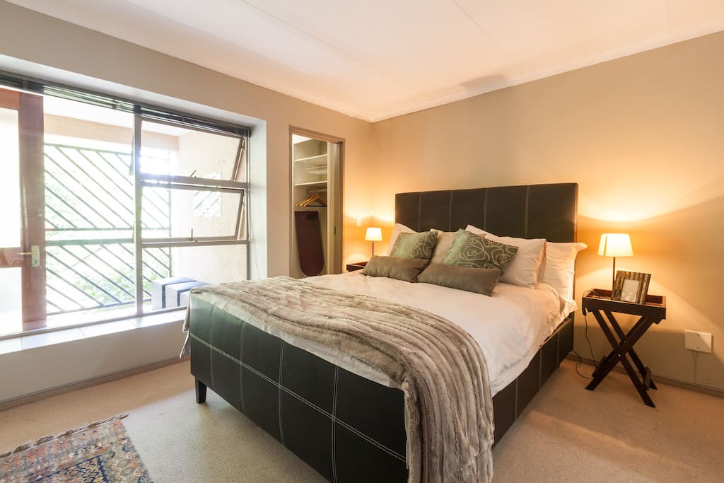 Main bedroom with an extra length queen sized bed extra length pillows all covered in the highest quality cotton linen. The main bedroom boasts a small en suite bathroom with a shower as well as a large walk in wardrobe with a set of wooden hangers.
