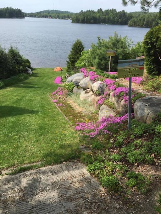 A paradise awaits you Plush gardens all the way down to the lake.