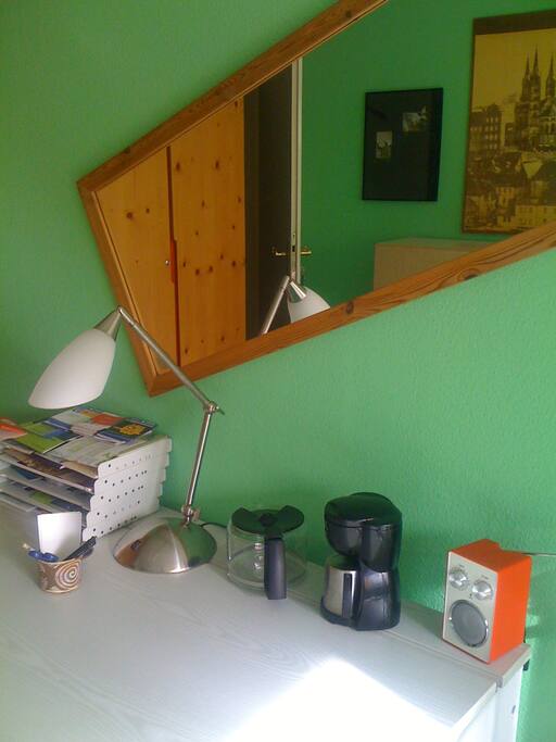Schreibtisch mit Ein-Tassen-Kaffeemaschine, Radio und gespiegeltem Schrank