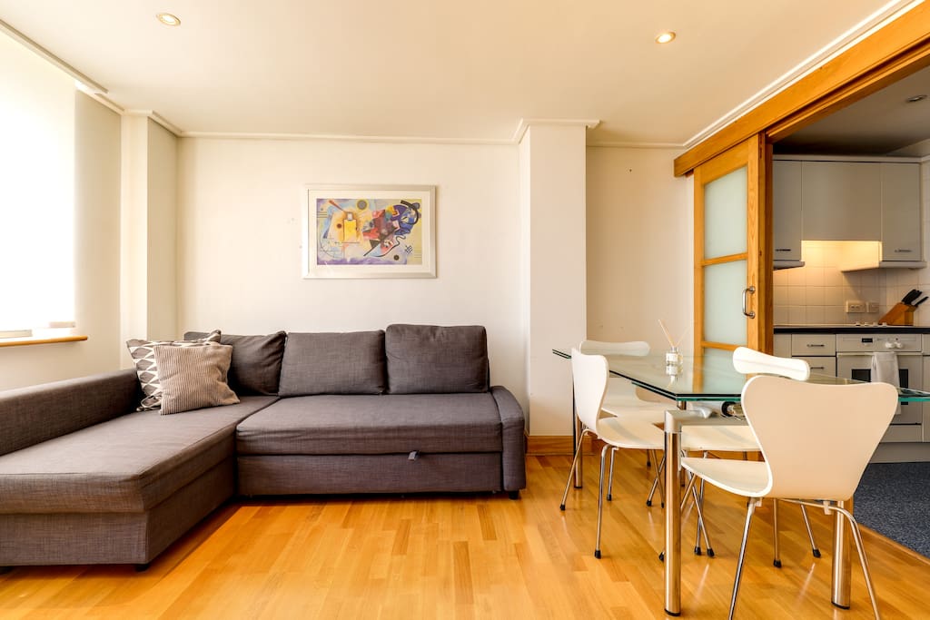 The living room is bright with sleek wooden floors.