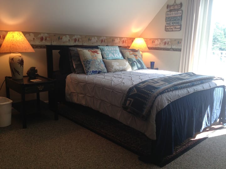 Newly renovated modern 12 x 20 carpeted bedroom with air conditioning, new queen bed, new linens, ample pillows, lake decor and lake views.