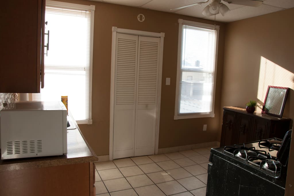The kitchen features a microwave, pots, a pan and dish-ware.