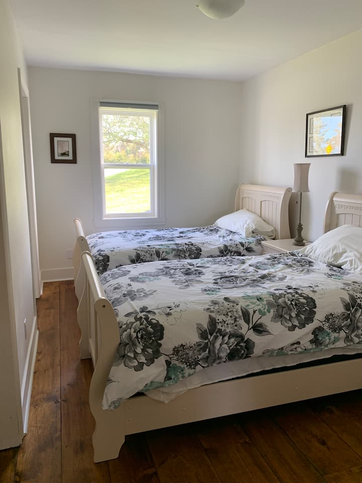 غرفة النوم الخلفية في الطابق الرئيسي بسريرين مزدوجين.