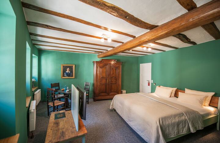 キングサイズベッド、テレビ、小さなシーティングエリアを備えたベッドルーム1