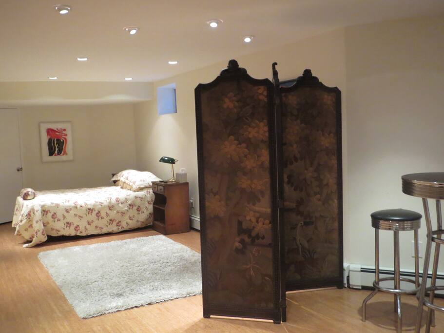 The studio room is divided with an antique screen into a sleeping space and a lounging space.