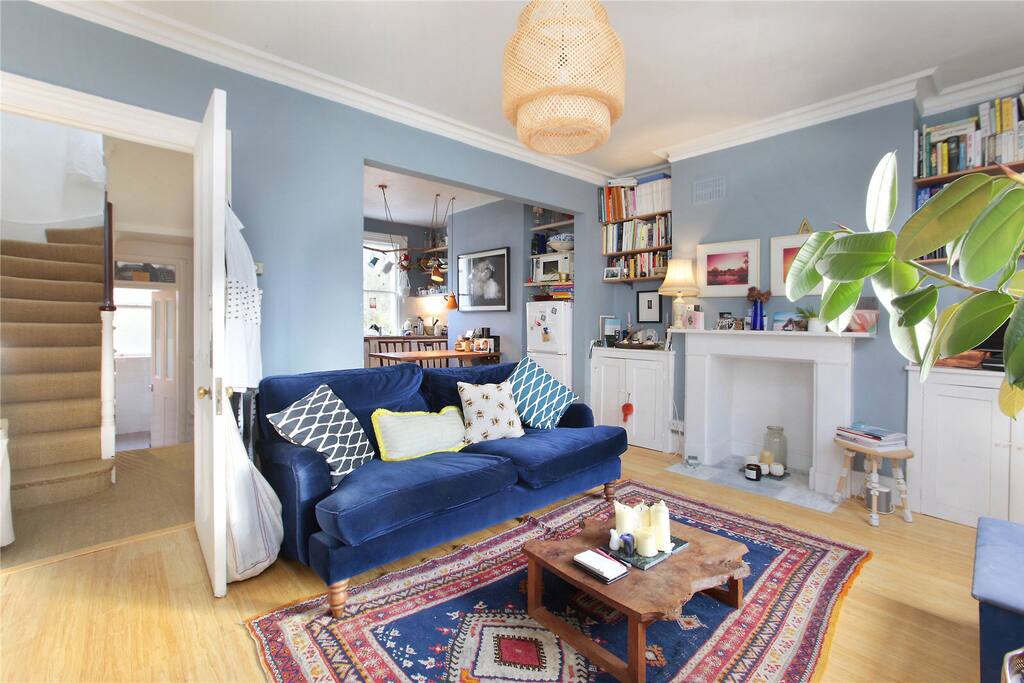 Our living room with blue velvet sofa, and you can see the bathroom at the end for the corridor and the stairs that go up to the second floor where the bedrooms are situated.