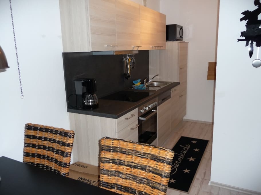 Küche mit Mikrowelle, Backofen, Geschirrspülmaschine, Kaffeemaschine,
Toster und allen Kochutensilien
