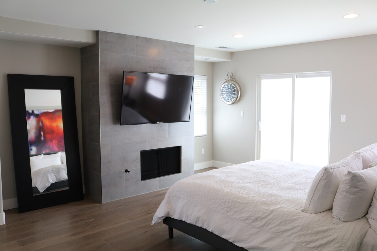 غرفة نوم رئيسية بسرير كاليفورنيا كينج ومدفأة