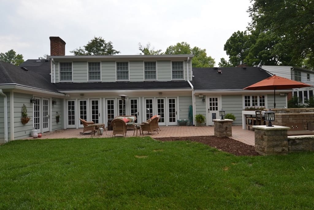 Great outdoor living space, with seating area, dining table and two grills.