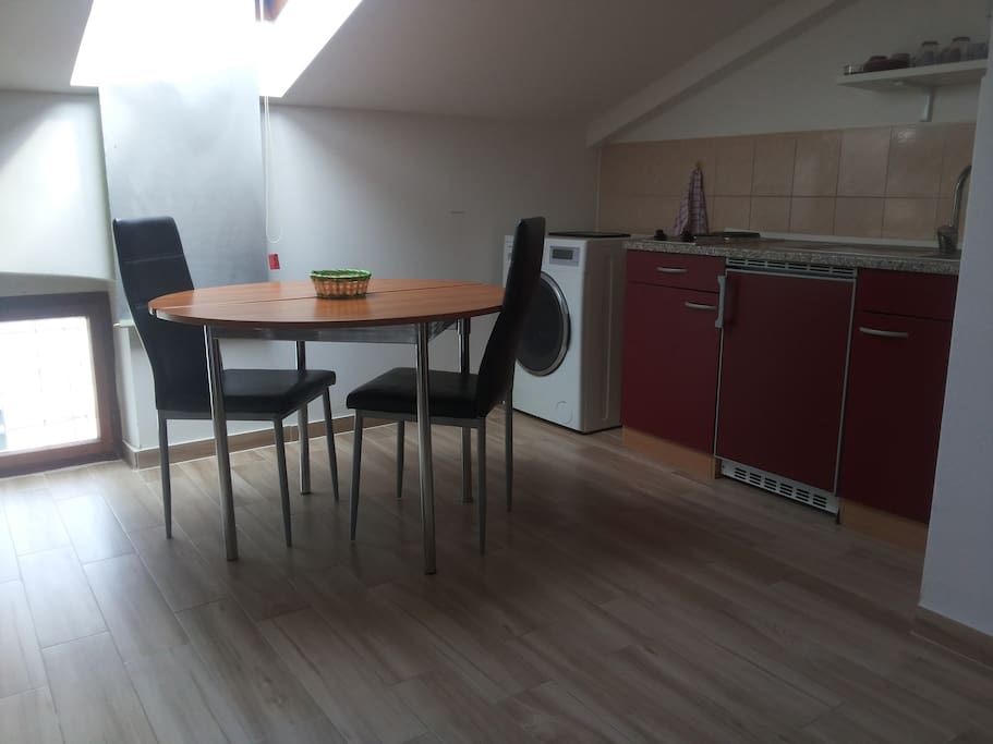 Large room which serves as the living, and bedroom, and a wing for the kitchen and a dining area.