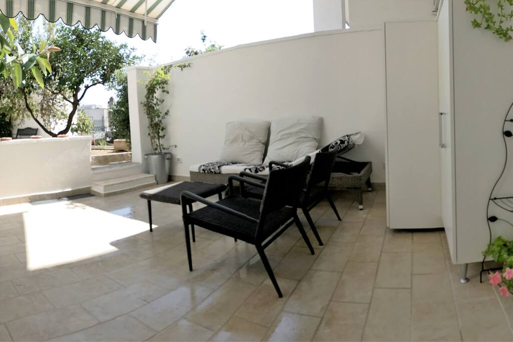 Cortile attrezzato con divanetti e barbecue