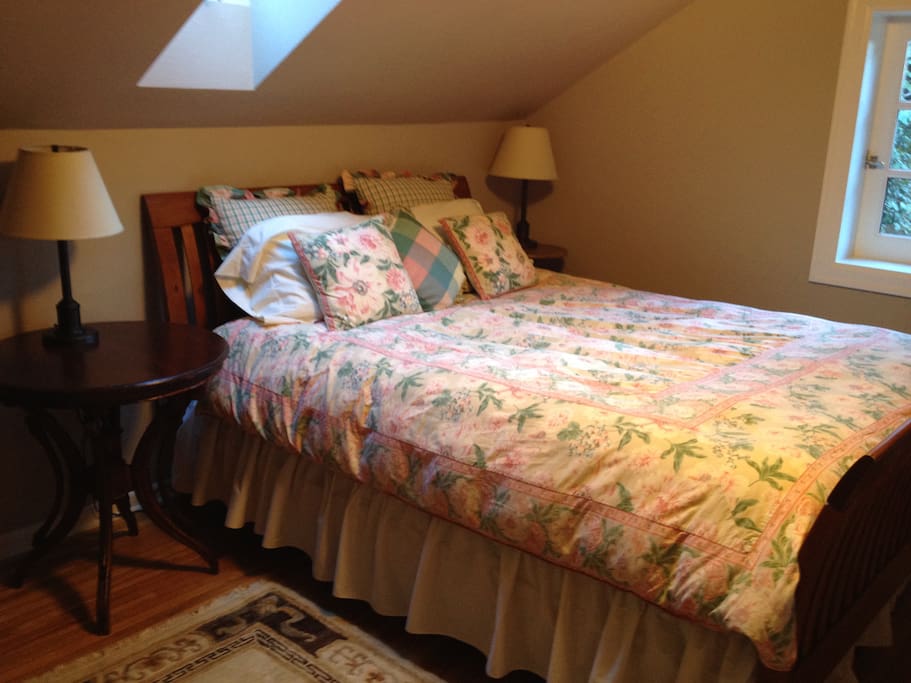 East bedroom with queen bed, skylight overhead