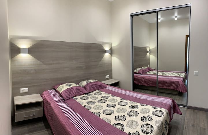 A separate bedroom with a mirrored wardrobe and doors