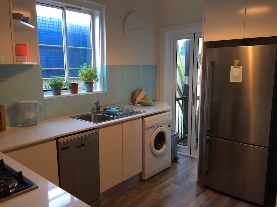 Renovated kitchen with small juliet balcony, washing machine, dishwasher and gas stove.