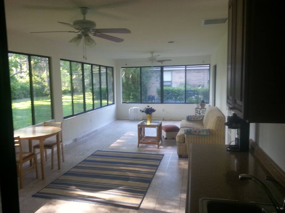 Backyard entrance into sunroom. Small fridge, microwave, nuwave class cooktop burner, coffeemaker in small kitchenette area.
