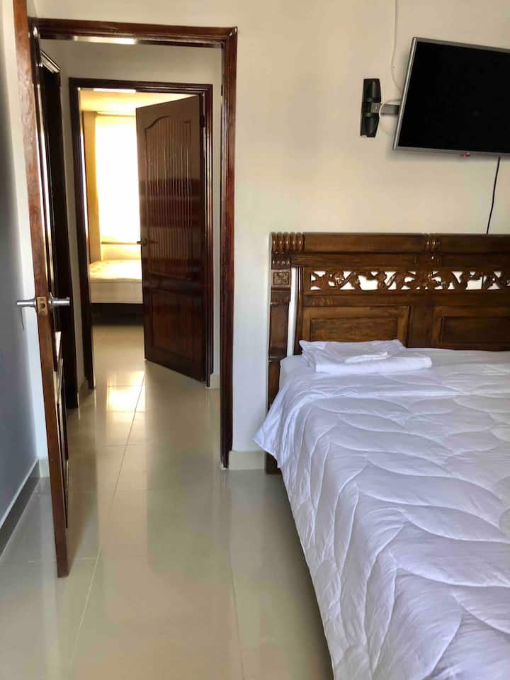 Chambre principale, lit King et lit jumeau. Climatisation, télévision et salle de bain attenante.