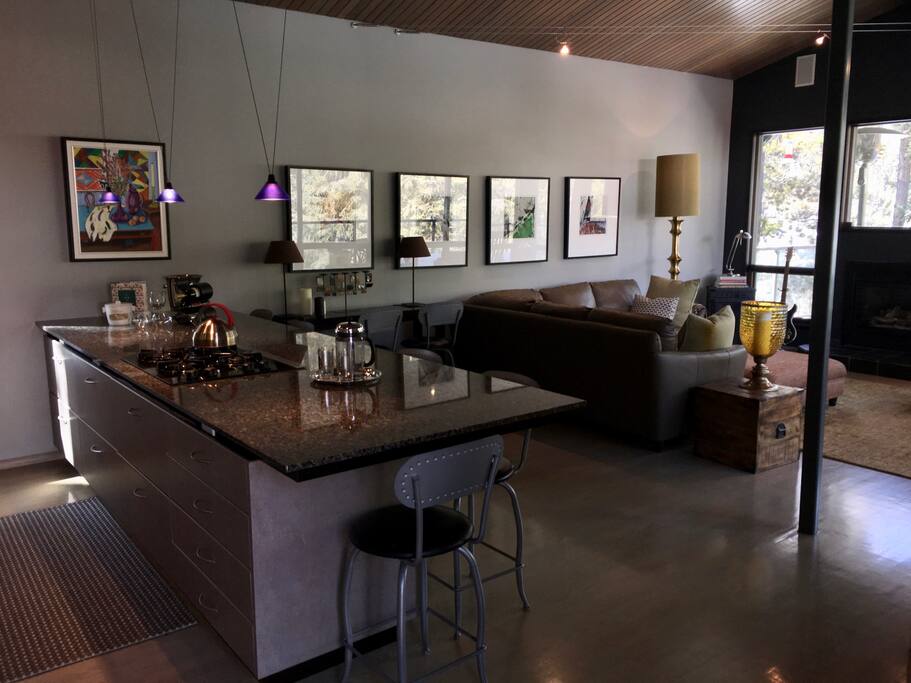 The main family room features a fully equipped kitchen including island seating for 8 people, a living room with a fireplace & awesome 360 degree panoramic mountain views.