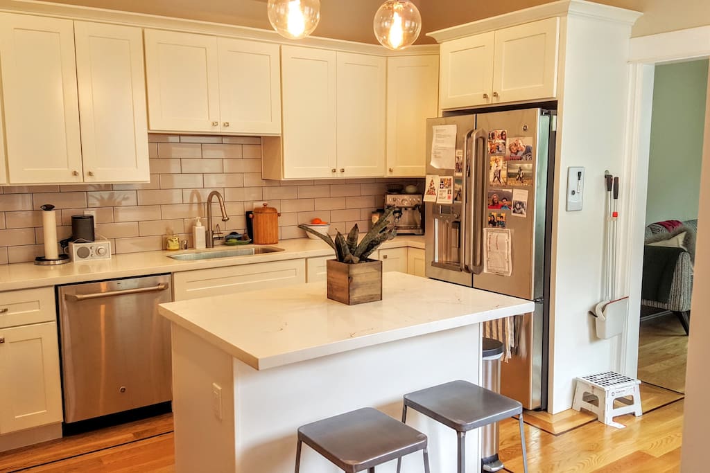 Kitchen island has seating for two, leads into TV room