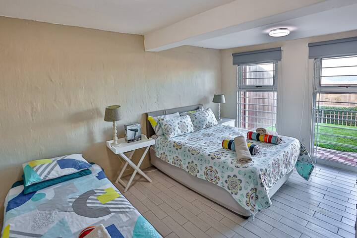 Habitación en la planta baja con cama Queen size, cama individual y aire acondicionado. 