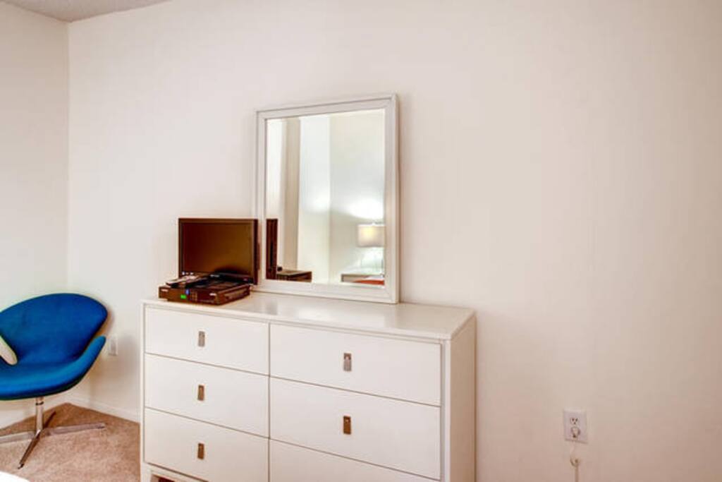 Private bedroom with dresser and flat screen TV