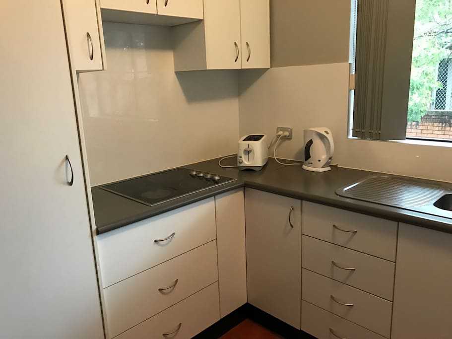 nice clean kitchen with mocrowave kettle toaster fridge and all other utencils