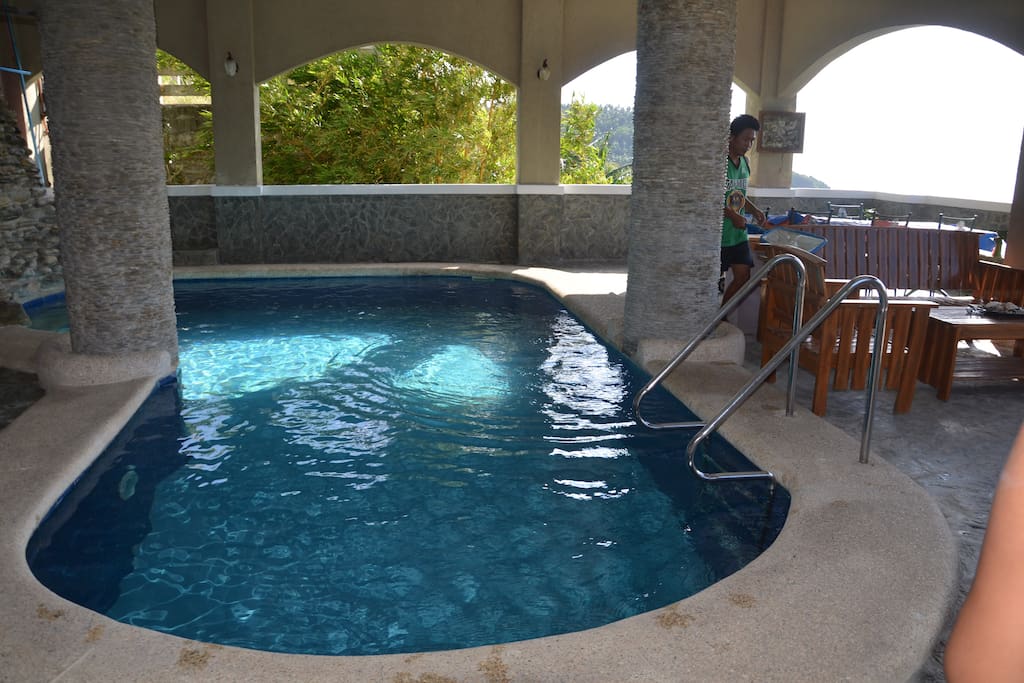 Private swimming pool with wooden table and chairs plus bbq grill