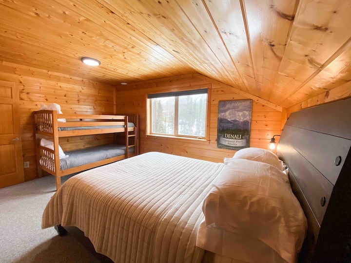 חדר שינה למעלה עם מיטת קווין סייז ומיטות קומתיים זוגיות. 