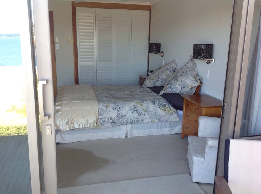 Guest bedroom opening on to deck with expansive views of lake.