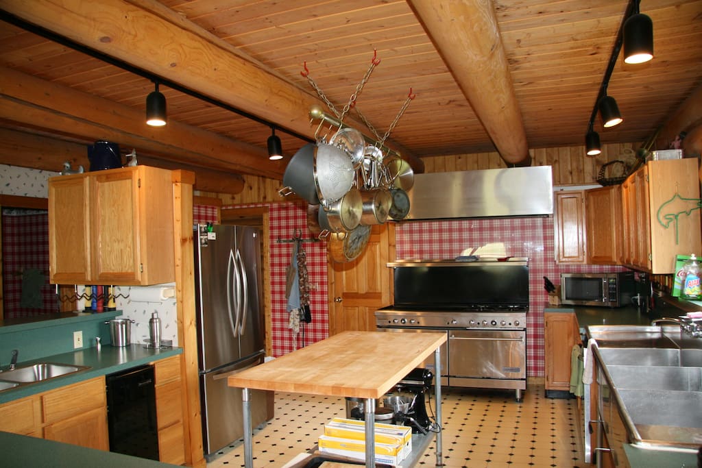 Fully equipped kitchen with a gas stove, griddle for flapjacks, triple sink, large cutting board island and a single sink. Everything the discerning chef would love to have.