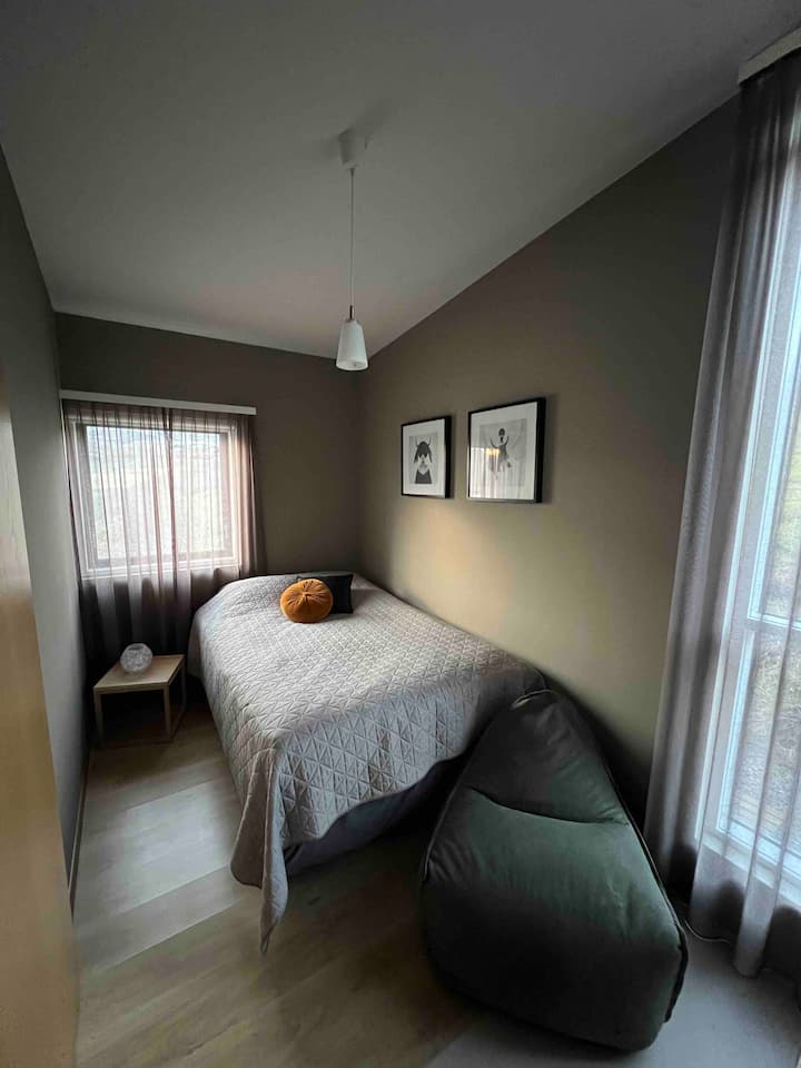A extra living room that serves as a cozy third bedroom, complete with a double bed and a TV for some entertainment. FYI The room has two windows and one of them doesn't have blinds.
