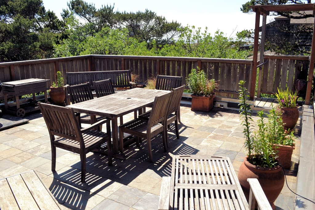 Upper south facing stone deck with gated stairs, charcoal BBQ and a patio table for 6.