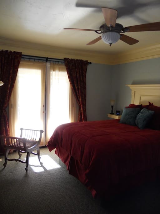 Spacious bedroom with a comfy queen bed. Handcrafted headboard and side tables. French doors lead out to you own private balcony overlooking Mariposatown.