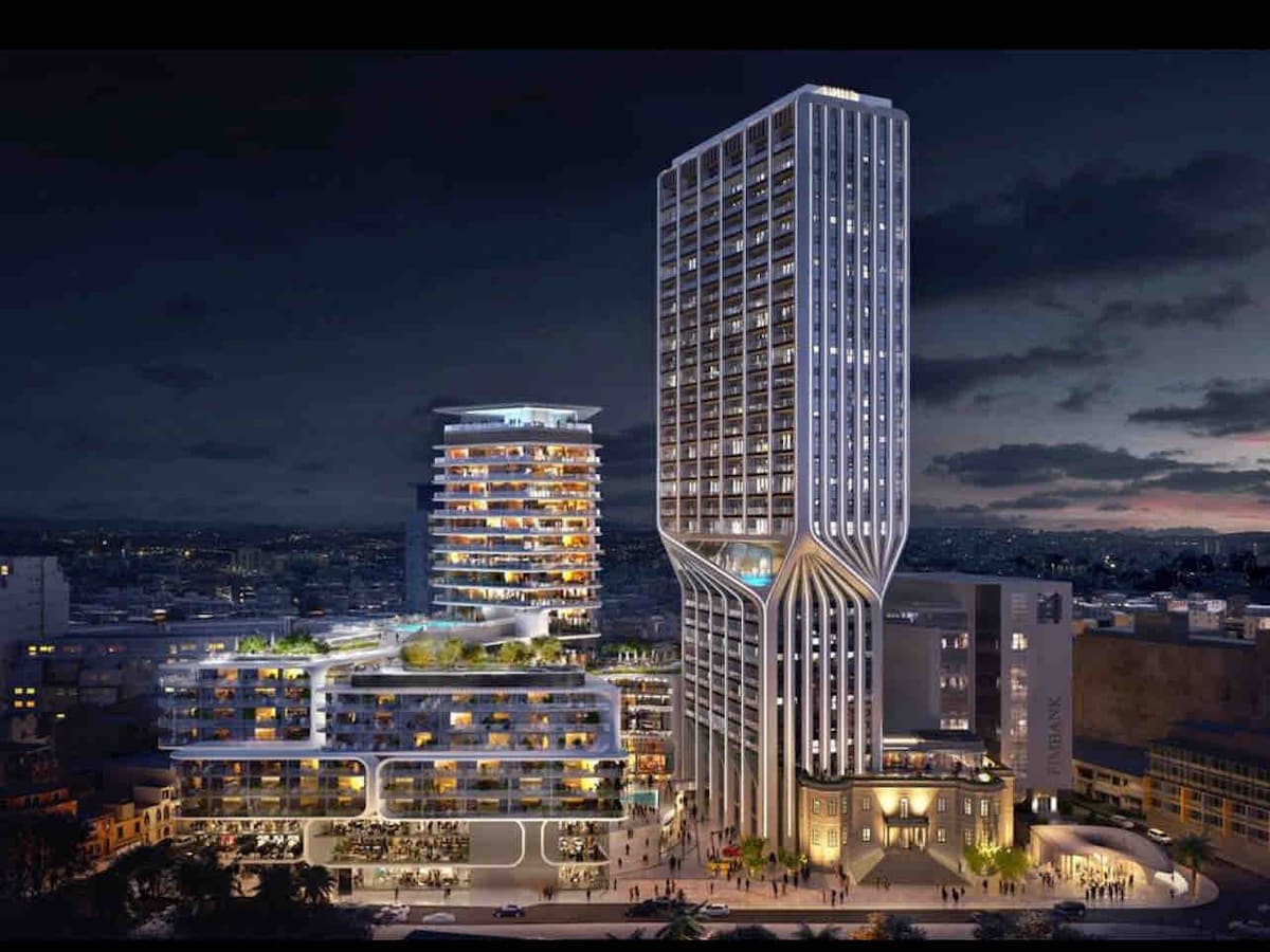 A modern high-rise building is showcased against a twilight skyline. Sleek architectural lines are highlighted, with expansive glass windows revealing various levels. Surrounding structures blend seamlessly, emphasizing an urban atmosphere. Soft lighting illuminates the façade and adjoining space, creating an inviting environment.