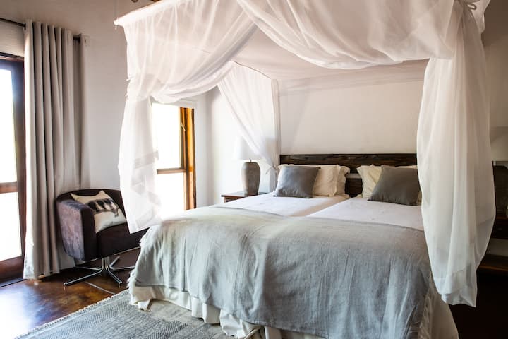 Chambre n °3 avec lit King Size, coin salon, armoire, bureau et salle de bain attenante avec douche.