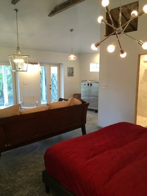 View of living space from corner looking towards bathroom and open space.
