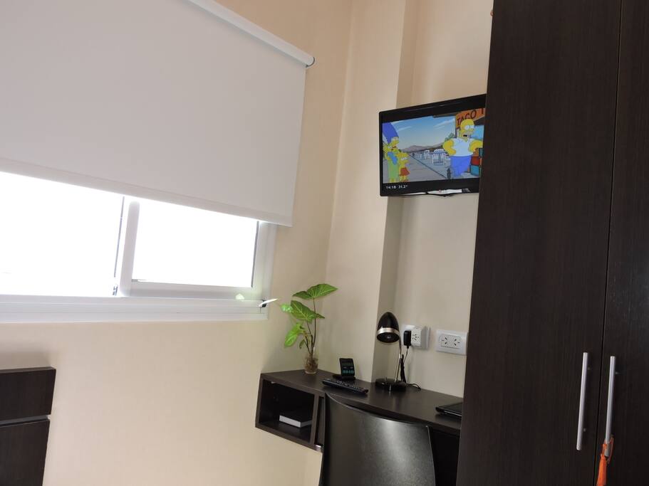 View of room with cable TV and working desk