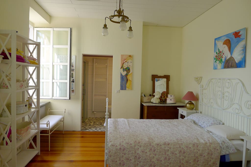 Gemütliches und ruhiges Schlafzimmer mit Regal, großem Spiegel und Kleiderschrank