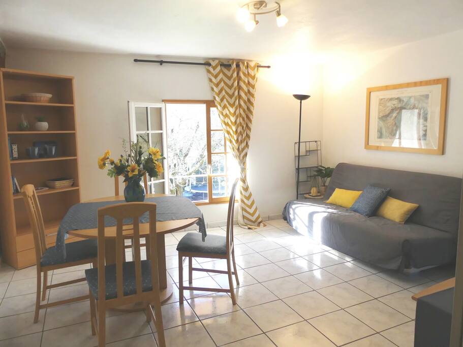 Séjour avec canapé lit et table pour 6 personnes (vu à partir de la cuisine)