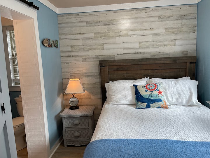 Dormitorio principal en la planta baja con una cama tamaño queen y baño privado.