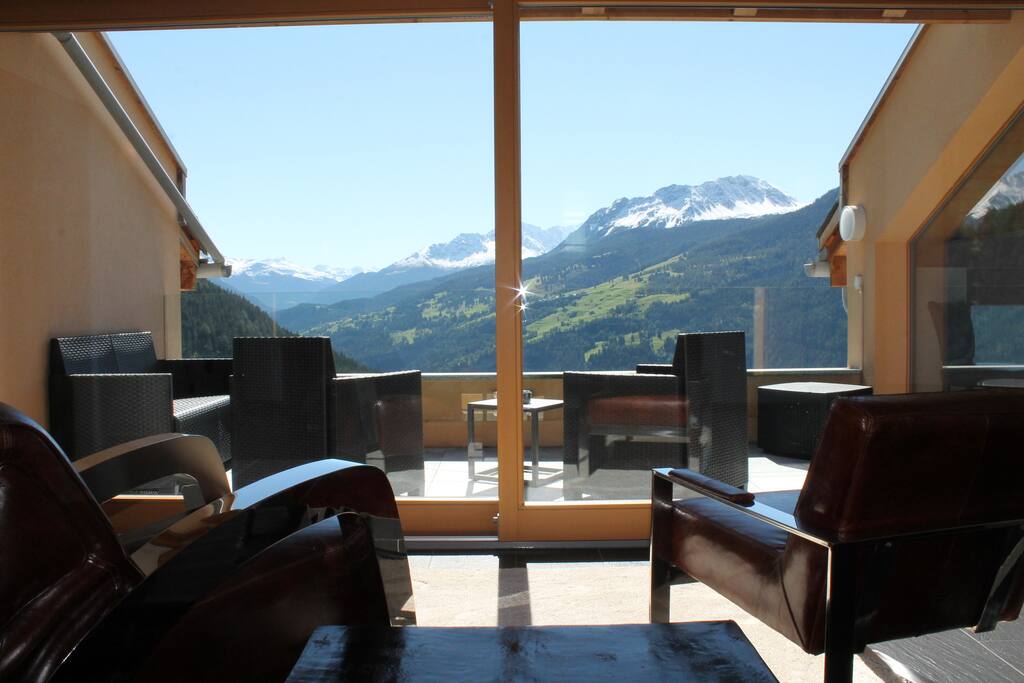 Innen: Leseecke in entspannender Atmosphäre und phenomenaler Aussicht. Aussen: Rattanlounge
