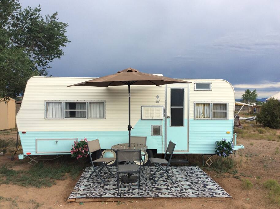 A classic "canned ham" trailer located in a beautiful spot with a big tree providing shade for most of the day.