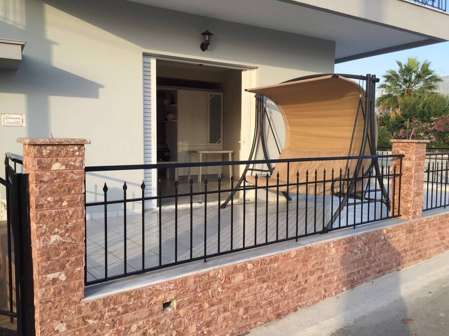 Große Terrasse mit einer Hollywoodschaukel und Tisch