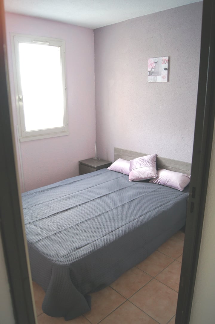 غرفة نوم رئيسية بسرير مزدوج وستائر بكرات معتِّمة