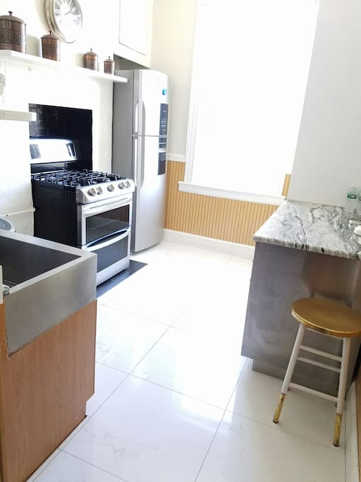Farmhouse kitchen with modern updates: gas range, farmhouse sink, gas range, stainless refrigerator and dishwasher