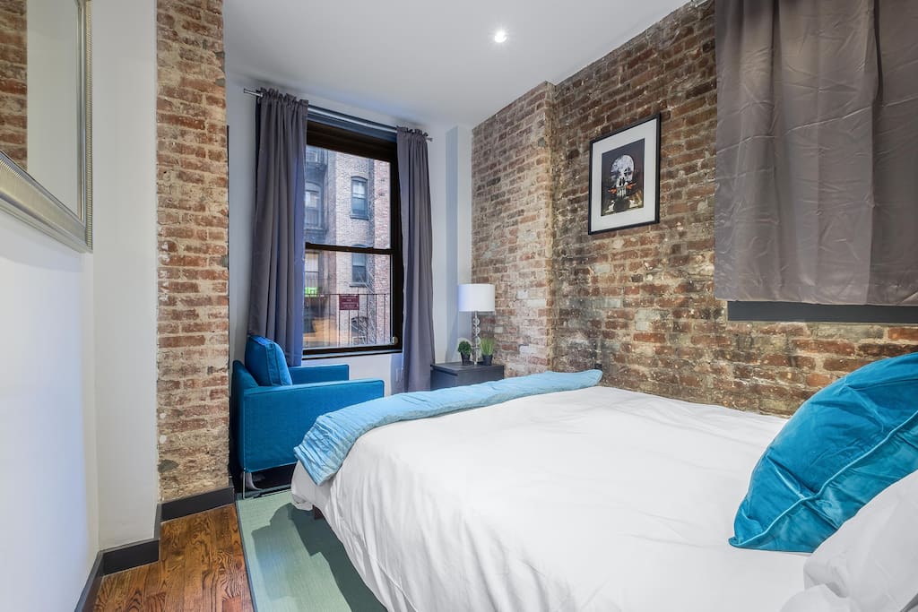 Beautiful brick exposed room with comfy bed and natural light