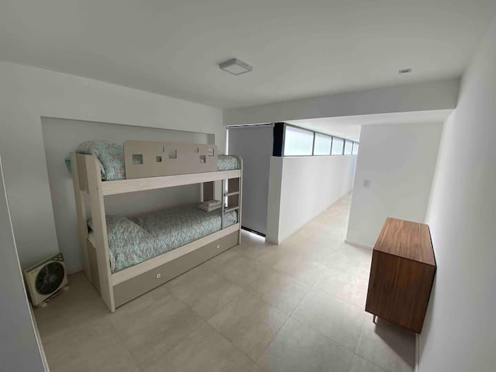 غرفة علوية مع سريرين مع مرتبة سومير وسرير بحار آخر